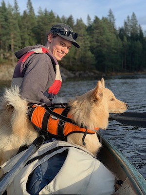 Kevin in a boat with dog